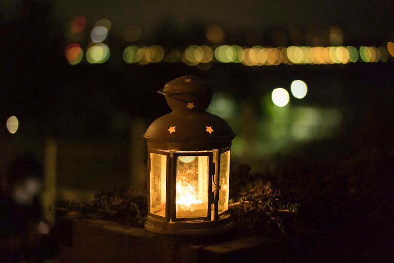 A glowing lantern creating a warm ambiance with bokeh lights in the background, ideal for festive themes.
